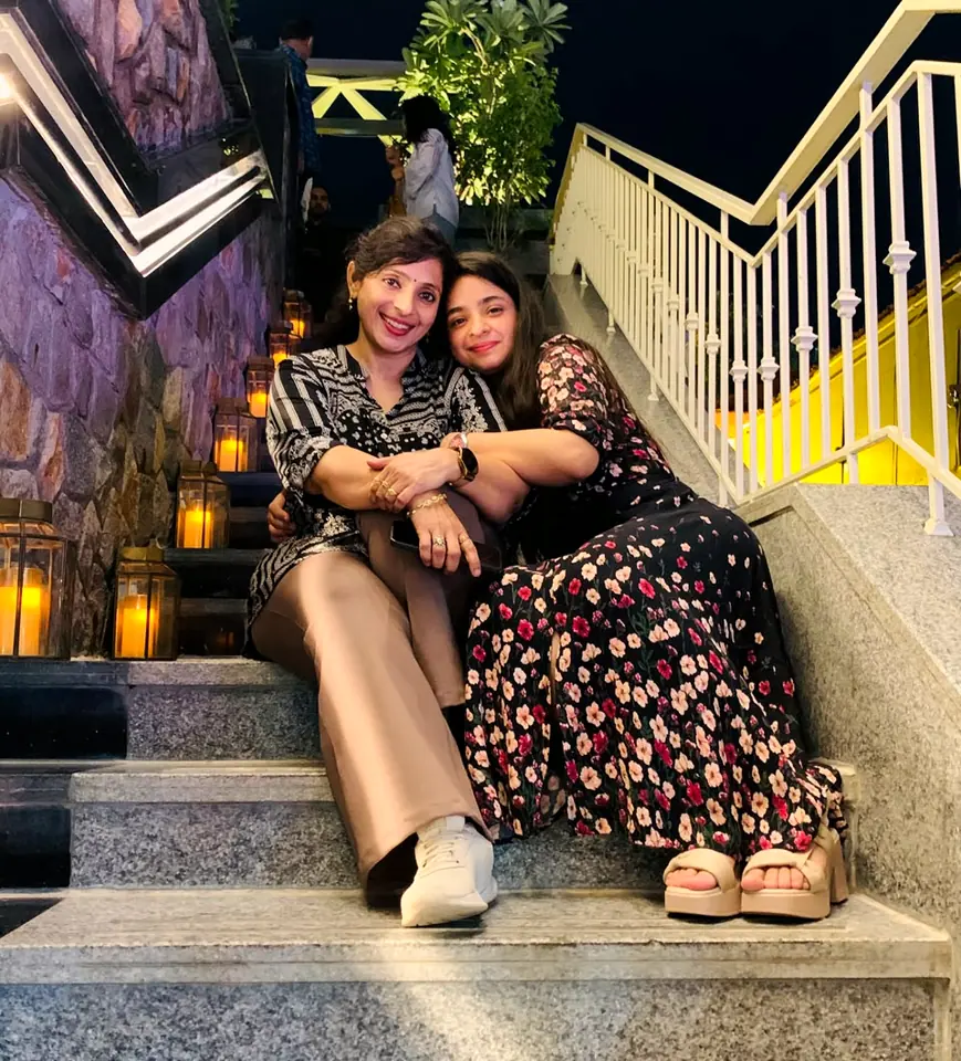 Dr. Reena Soni and her daughter sitting together on lantern-lit steps